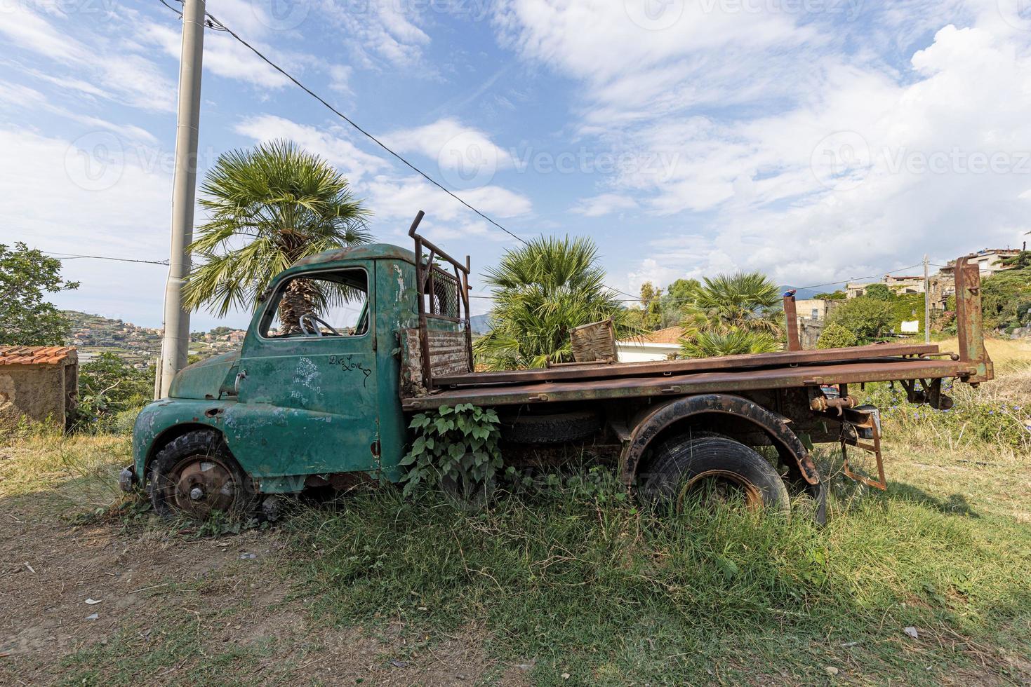 Picture of a weathered and unusable transporter in a field in daylight photo