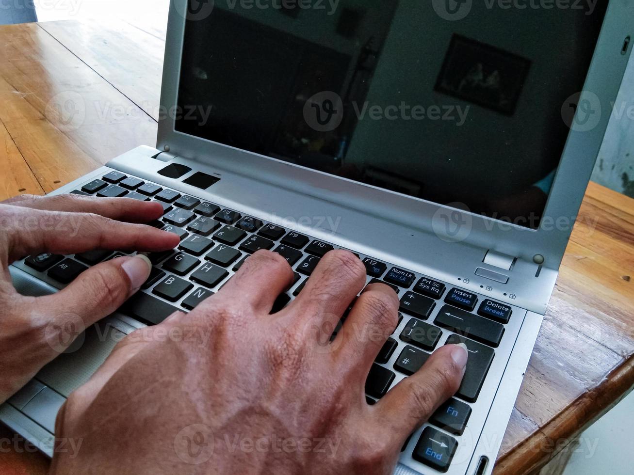 businessman hand working with laptop on wooden table photo