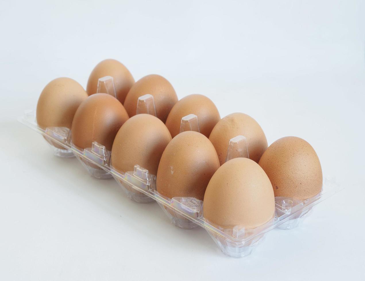 Close-up Happy Easter view fresh brown chicken raw egg several in egg box plastic isolated on white background. for cooking. Healthy eating photo