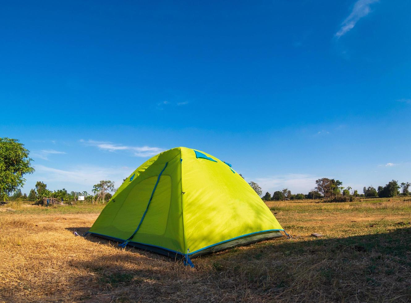 viajero carpa verde camping viajes al aire libre. vista desde la carpa interior sobre el sol azul del cielo en el paisaje de verano. durante la tarde del día adecuado para dormir y descansar el cuerpo foto