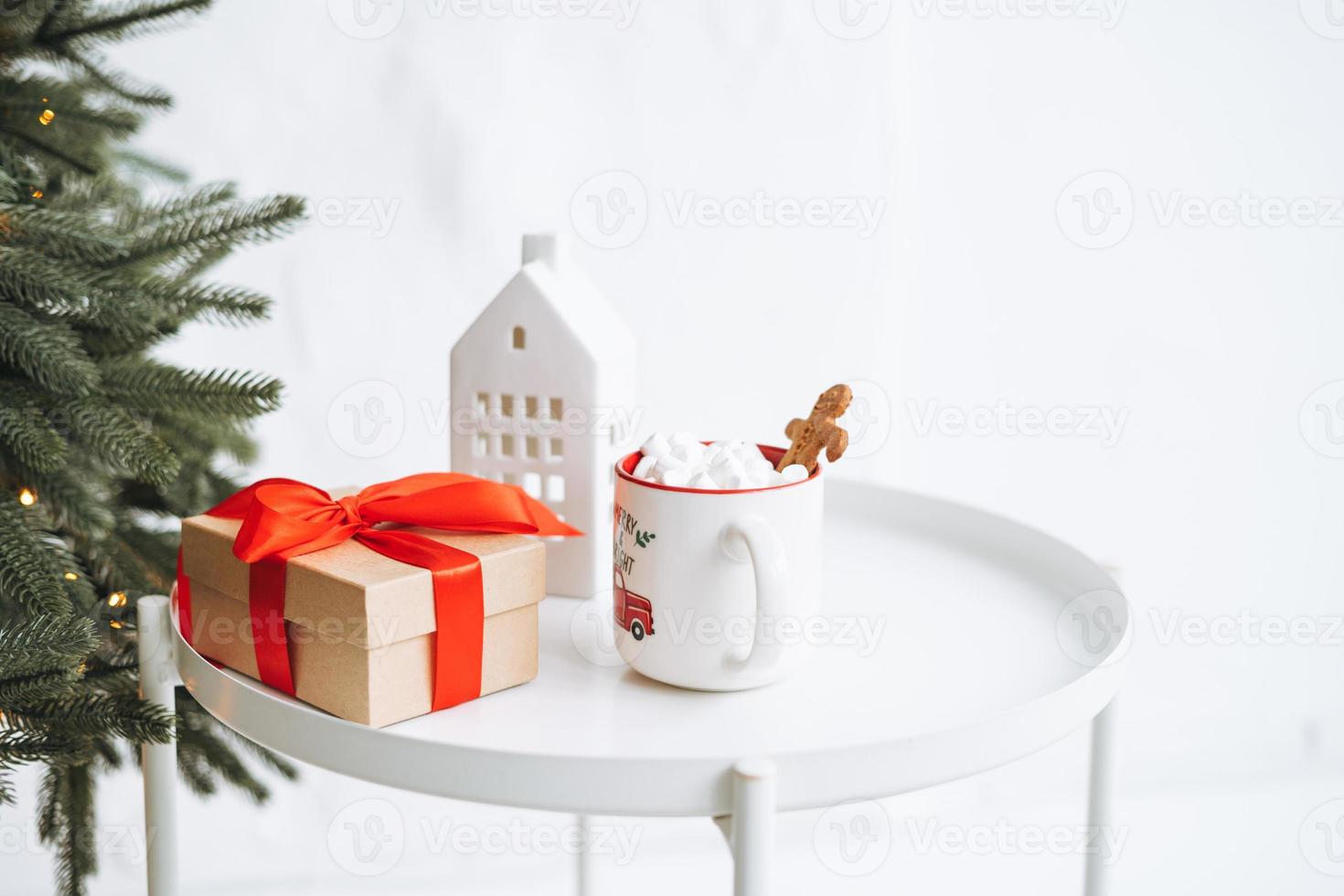 Bodegón navideño de caja de regalo presente, cacao con malvavisco en mesa blanca foto
