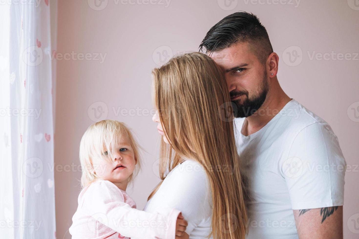 Happy multinational family father young man and mother with baby girl little daughter having fun in children room at home photo