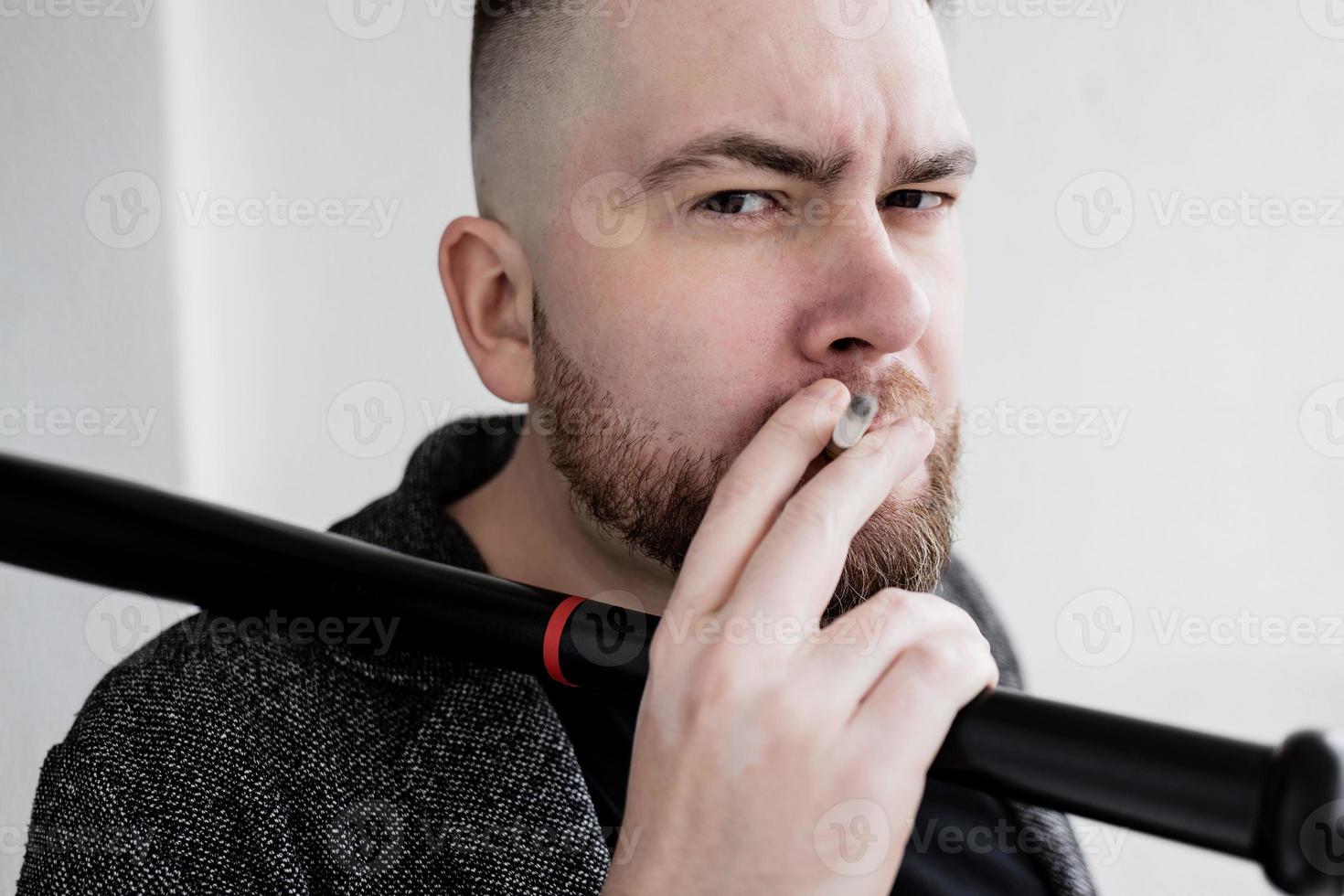 man of a bearded man with a bat and a cigarette photo