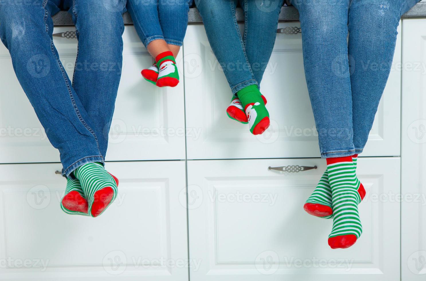 the concept of a happy family dressed in Christmas stockings in the kitchen photo