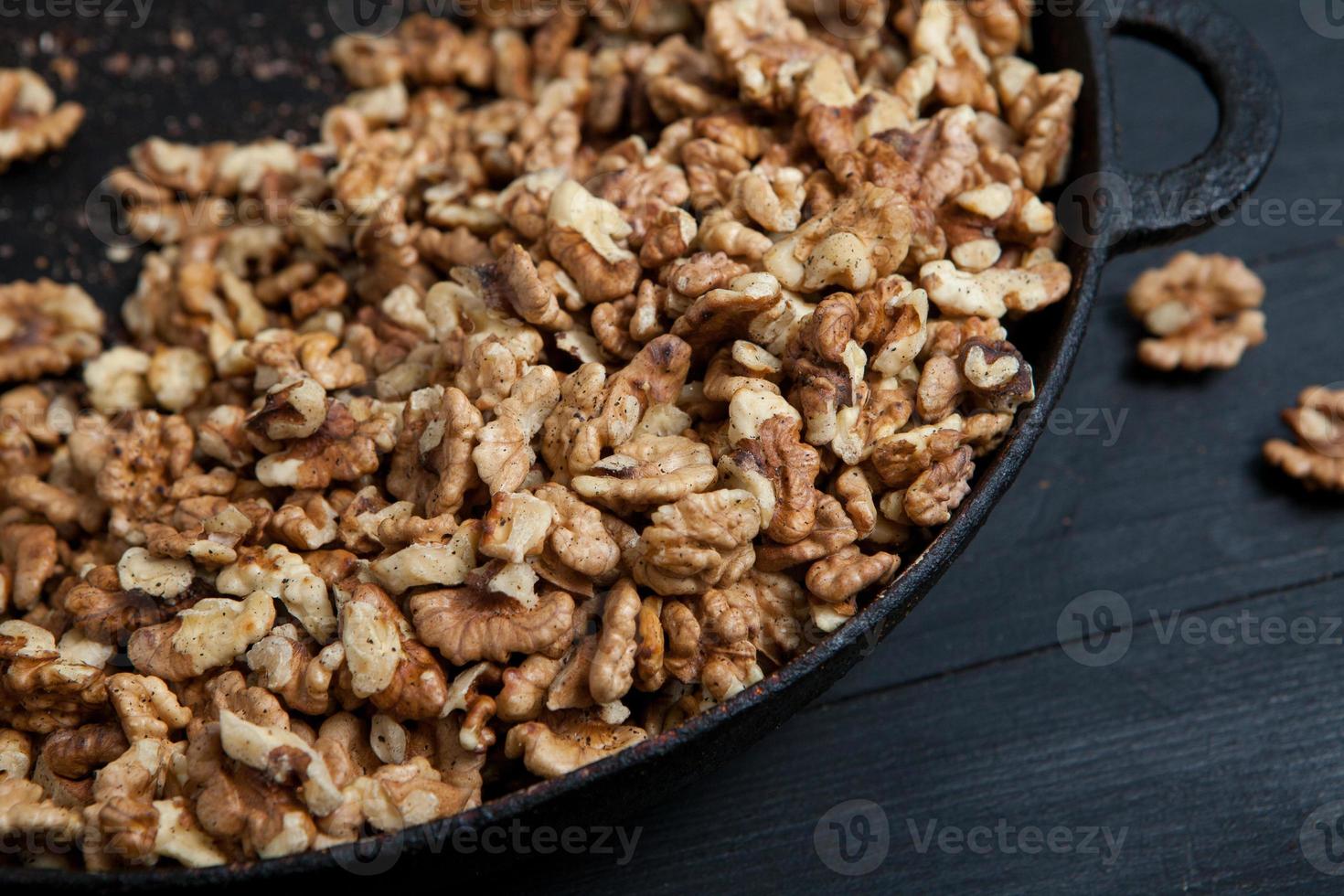 Walnut background. Peeled walnuts on a iron plate on black. walnuts a
