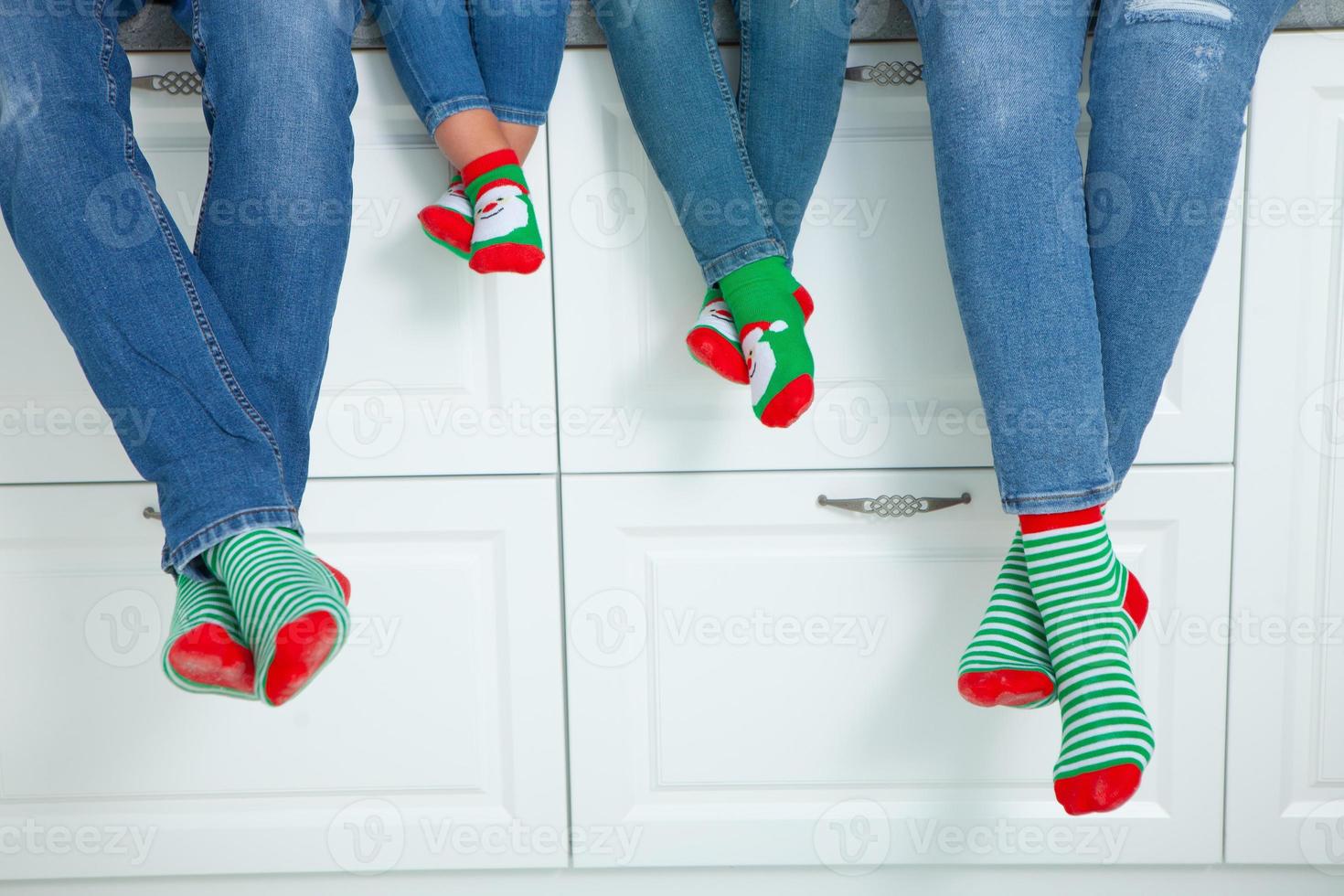 the concept of a happy family dressed in Christmas stockings in the kitchen photo