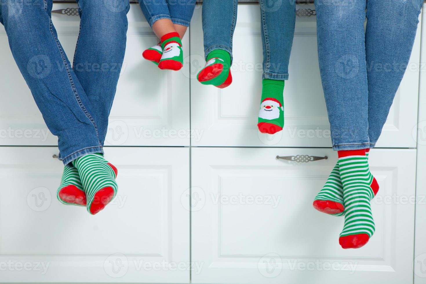 the concept of a happy family dressed in Christmas stockings in the kitchen photo