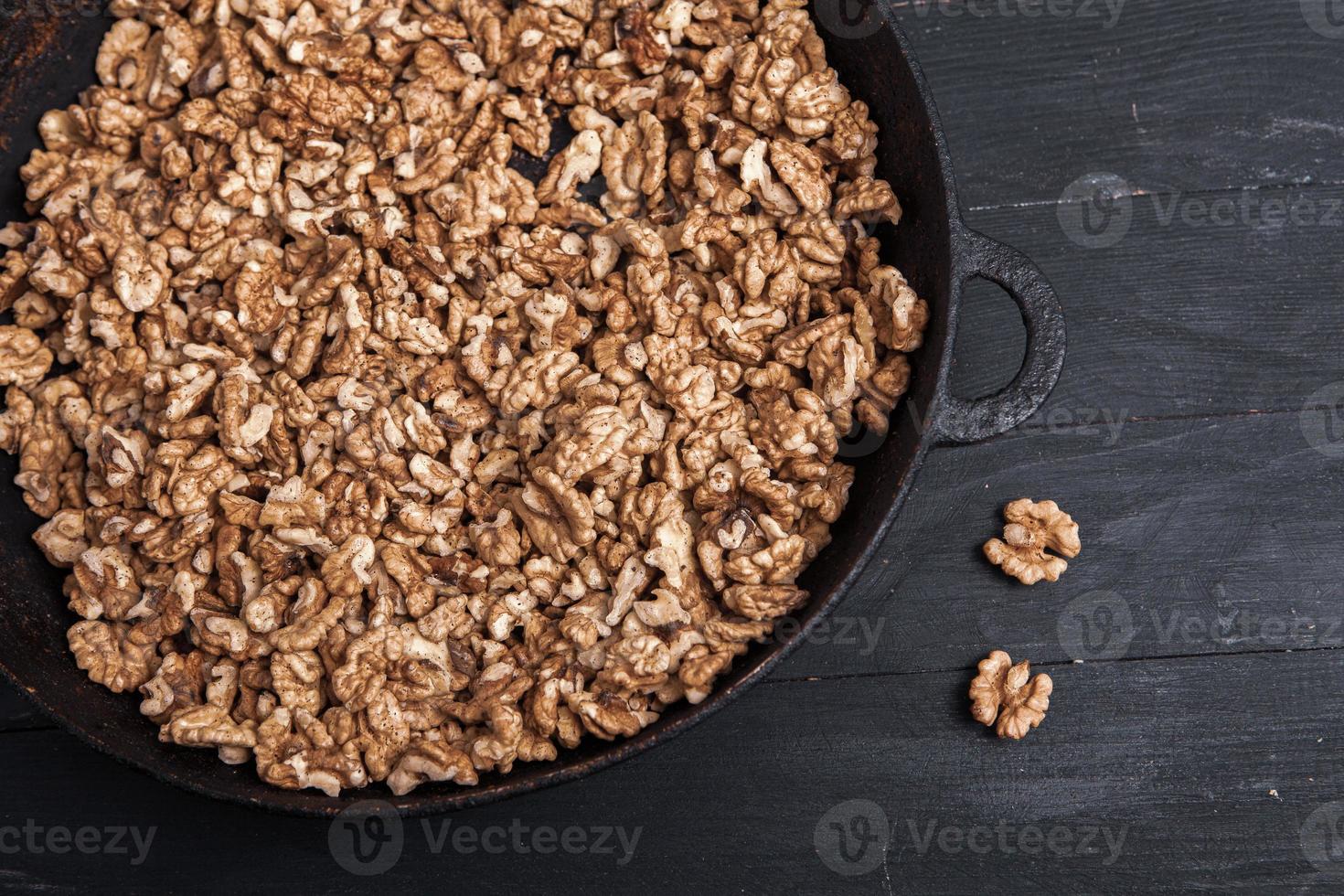 Walnut background. Peeled walnuts on a iron plate on black. walnuts a