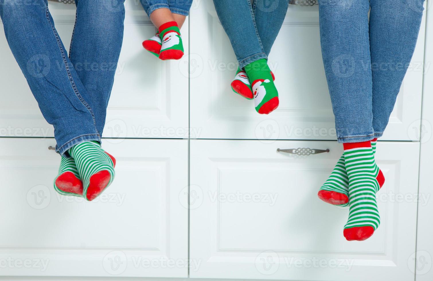 the concept of a happy family dressed in Christmas stockings in the kitchen photo