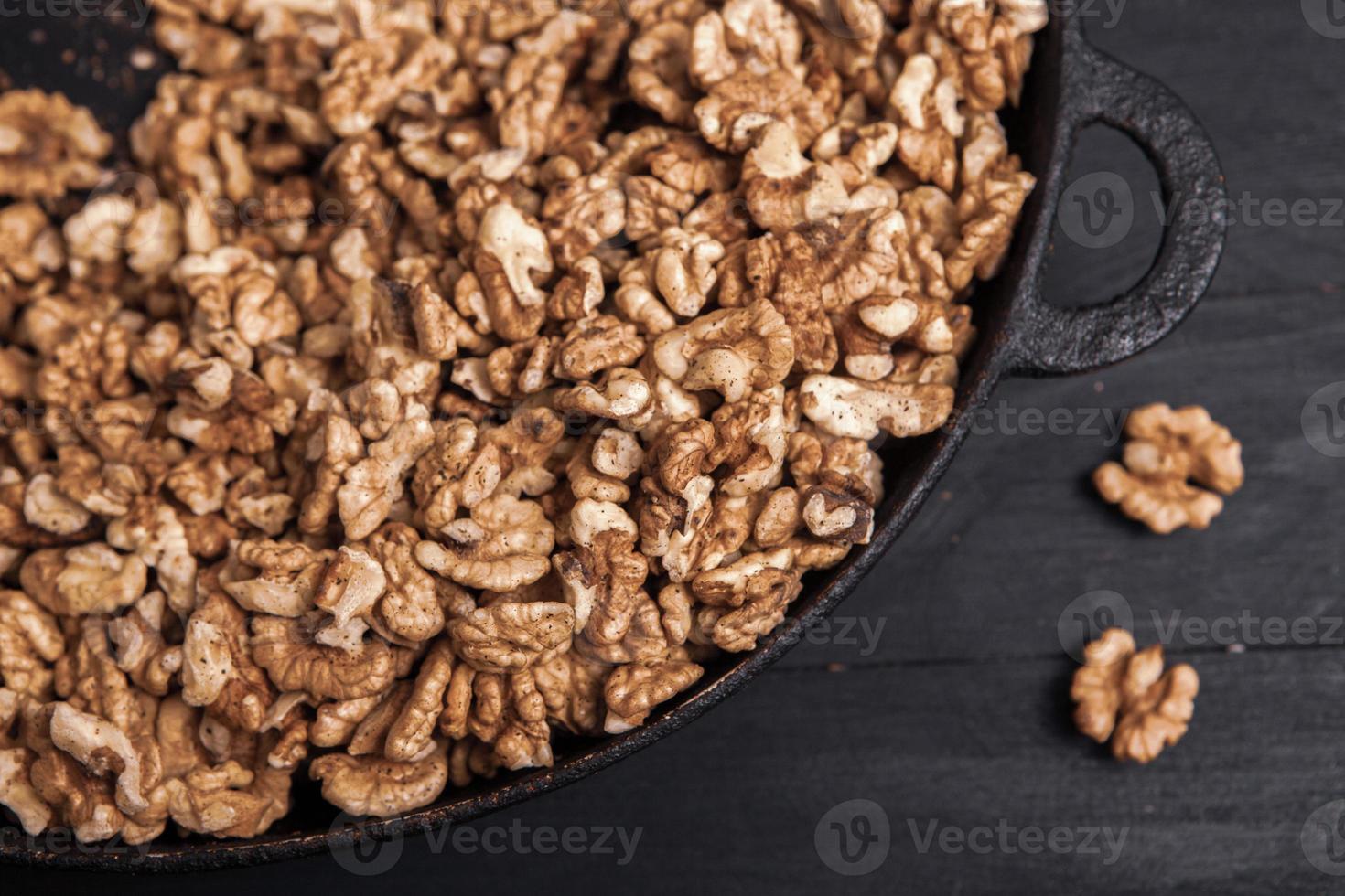 Walnut background. Peeled walnuts on a iron plate on black. walnuts a