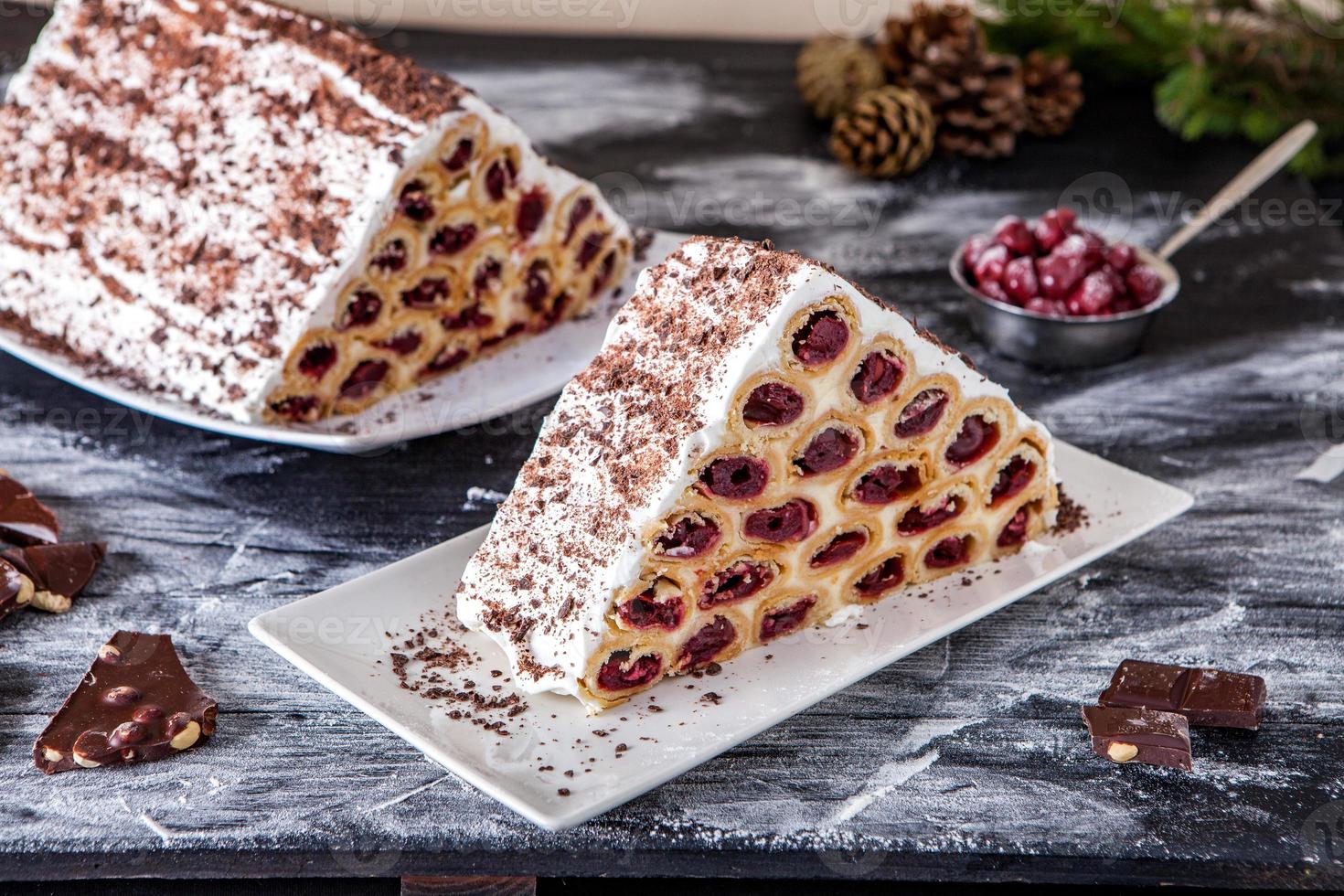 un postre o pastel moldavo tradicional que consiste en panqueques con cereza, crema de leche y crema de chocolate también llamado cosma lui guguta. foto