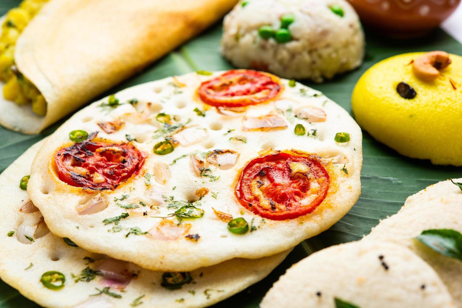 South Indian Masala Dosa, Uttapam, Idli vada sambar, semolina halwa, upma served over banana leaf photo