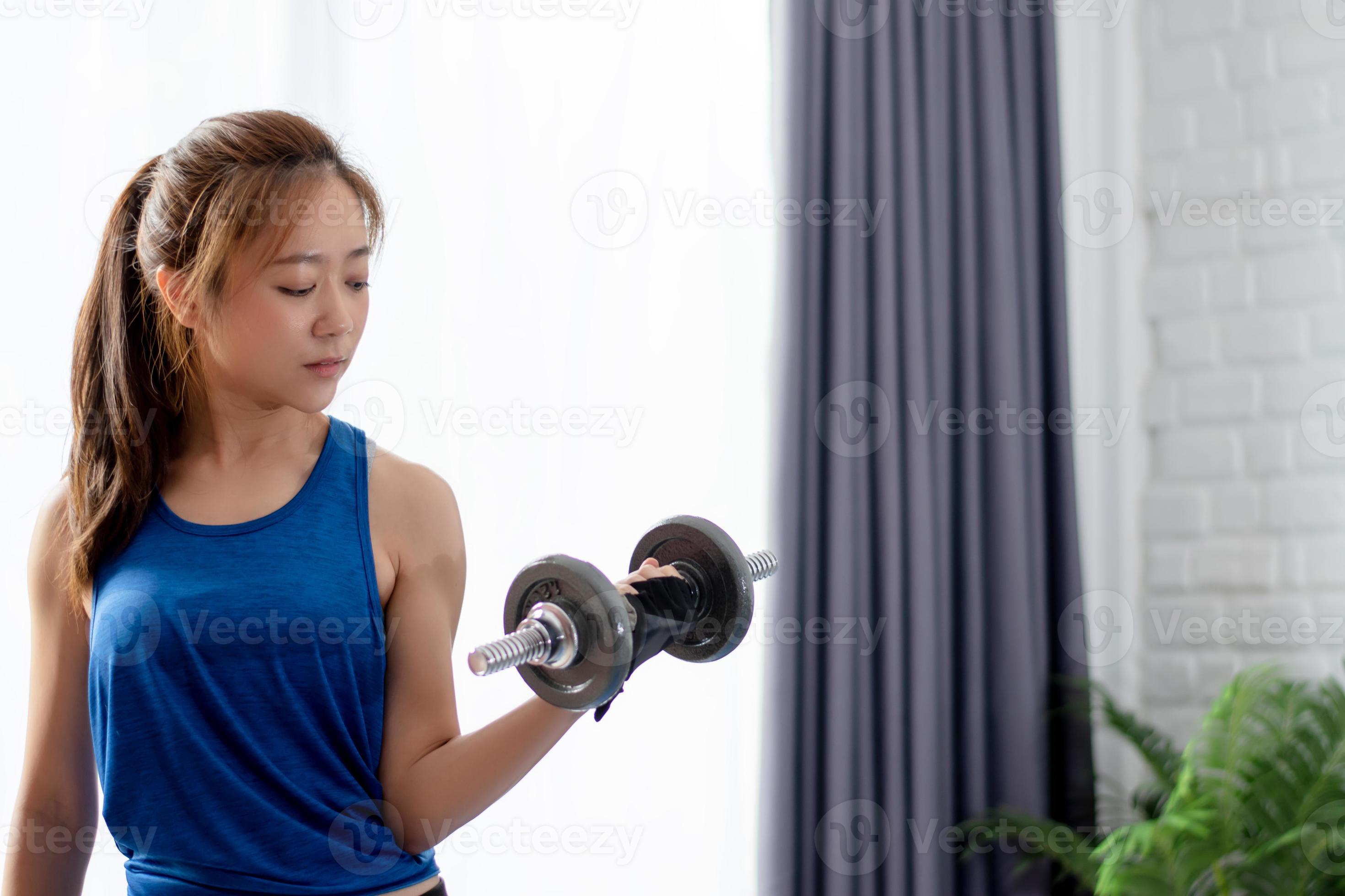 Asian women exercise to strengthen arm muscles at home. She is lifting  weights 15934699 Stock Photo at Vecteezy