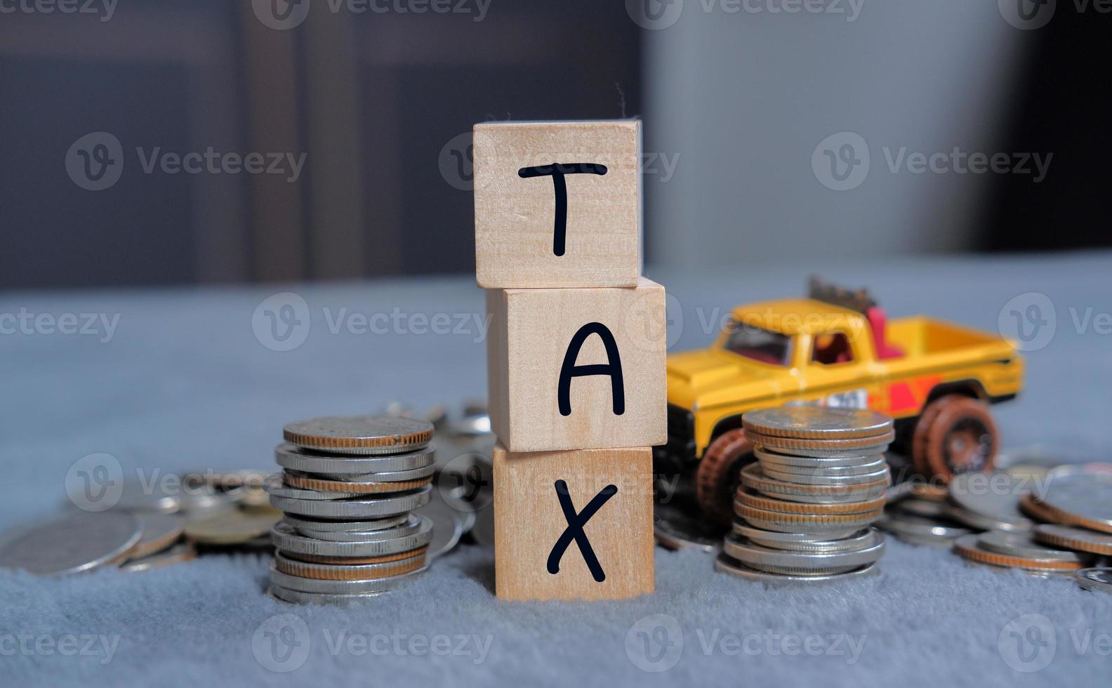 concepto de impuestos para automóviles en cubos de bloques pagados por individuos y corporaciones como IVA, análisis de datos de impuestos sobre la renta e impuestos sobre la propiedad, papeleo, investigación financiera. foto