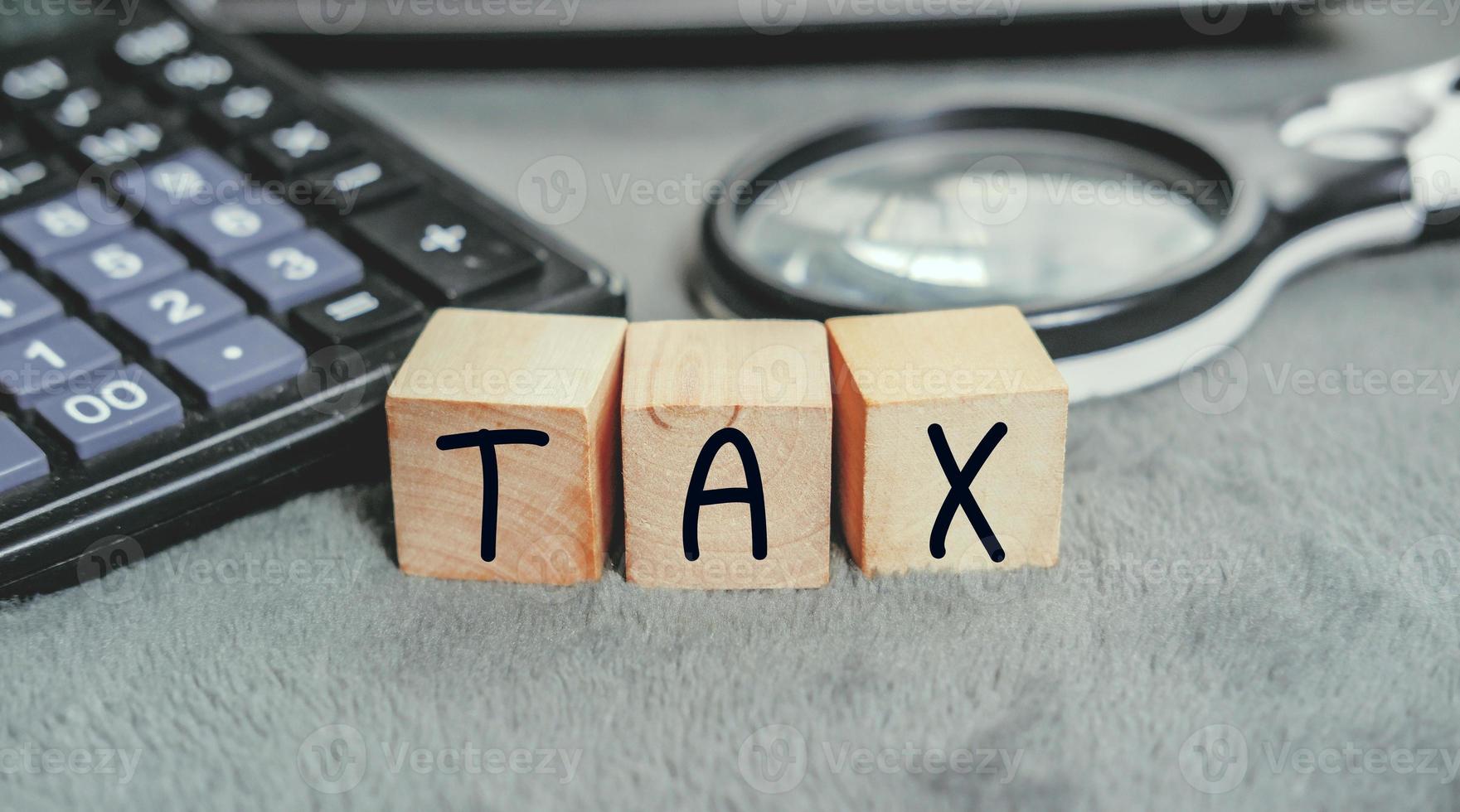 Concept of taxes paid by individuals and corporations such as VAT, income tax and property tax Data analysis, paperwork,Financial research,TAX on block cubes. photo