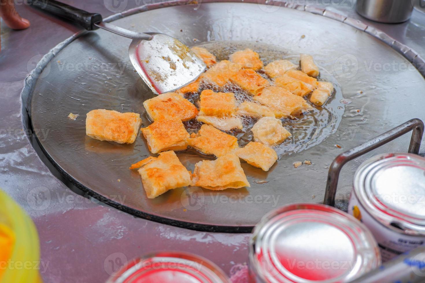 Roti dough on a hot pan is cooking. with seasonings on the table. photo