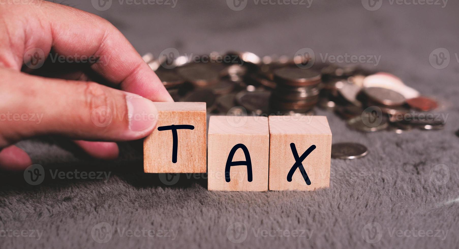 Concept of taxes paid by individuals and corporations such as VAT, income tax and property tax Data analysis, paperwork,Financial research,TAX on block cubes. photo