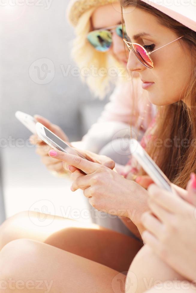 grupo de amigos que usan teléfonos inteligentes en la ciudad foto