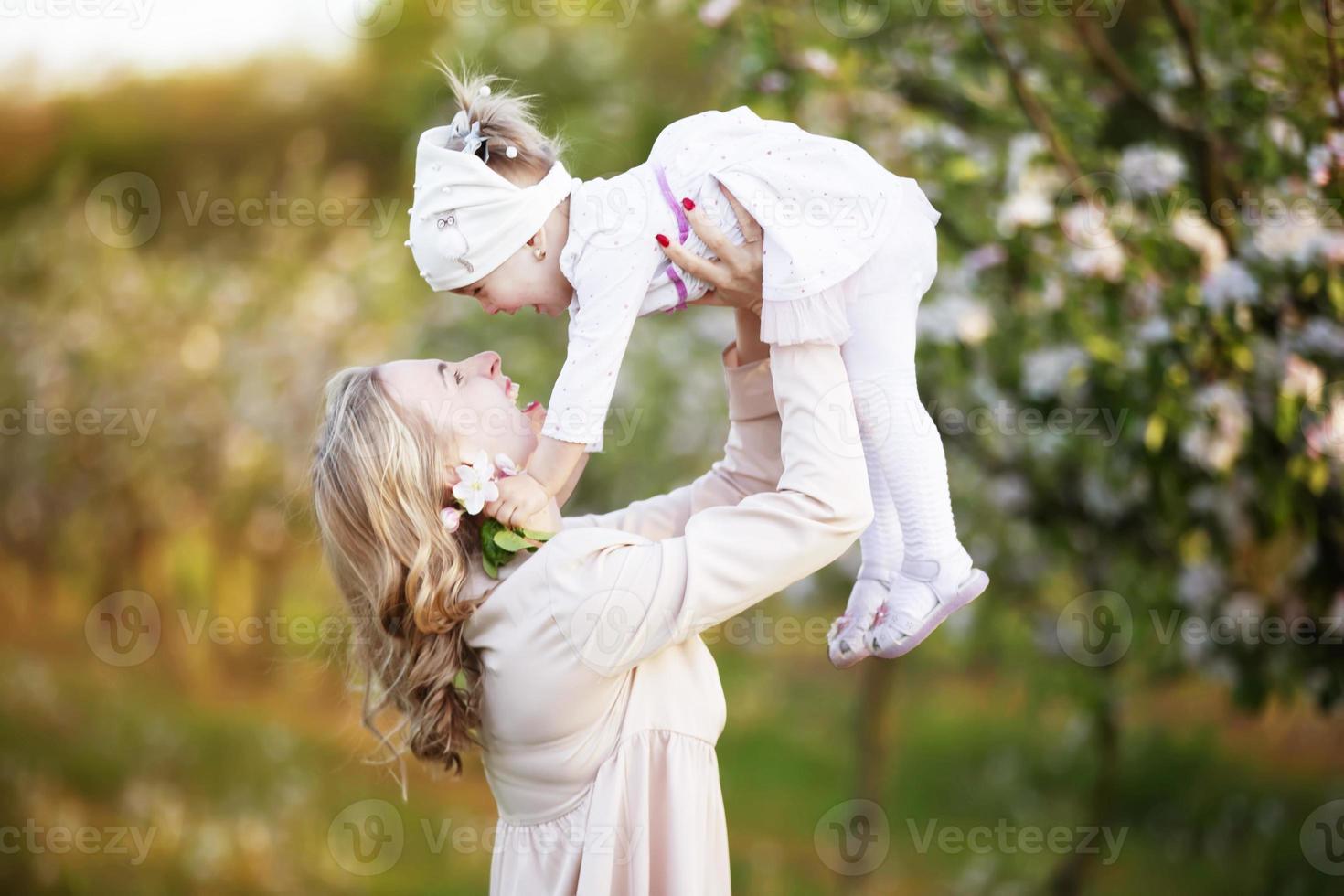 Mom with a little daughter in a blooming garden. Happy motherhood. Happy mother and little daughter portrait outdoors. mother's day concept photo