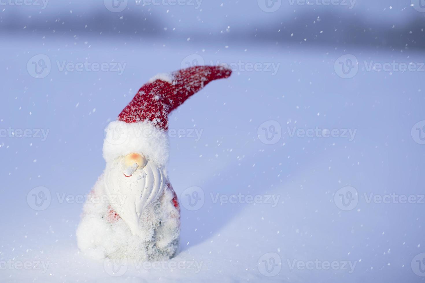 Toy Santa Claus on the background of falling snow. photo