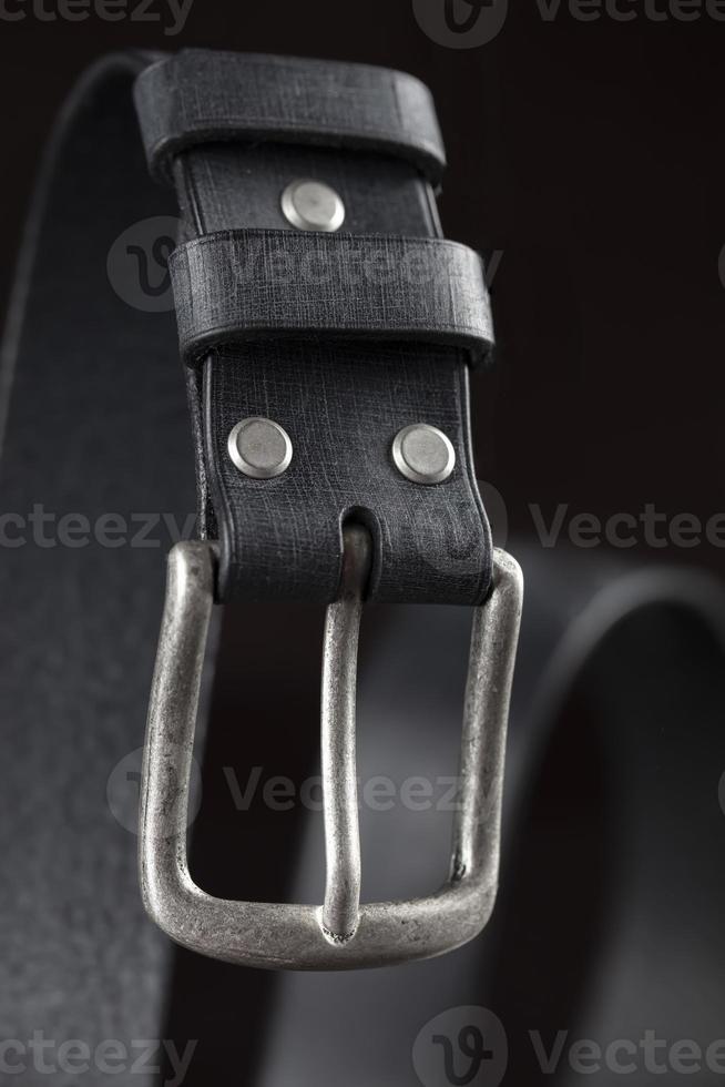 Black leather belt on a dark background. Leather products. photo