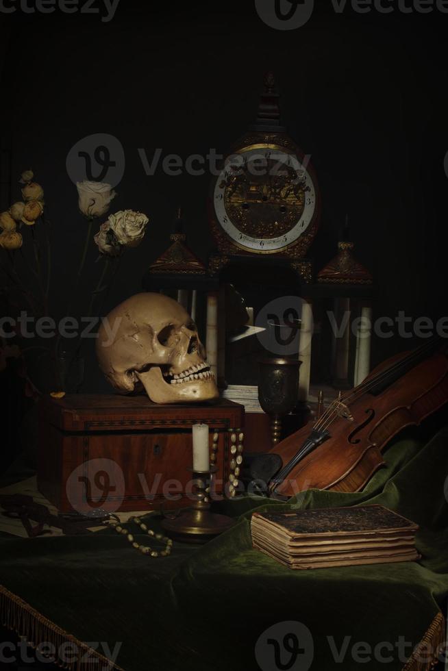 Close-up still life, Dutch painting of the 17th century. On the table on a black background are flowers, a skull, a clock, a violin, keys. Things that tell about a person's life. photo