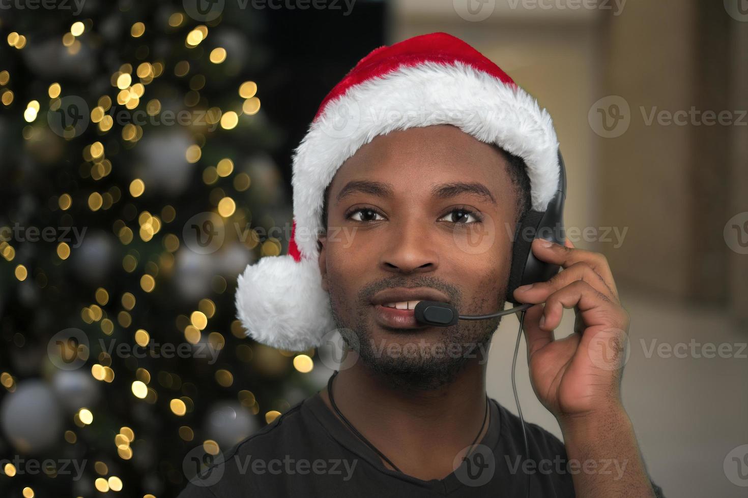 holiday support center christmas helpline customer service assistant wearing santa claus red hat and headset microphone photo