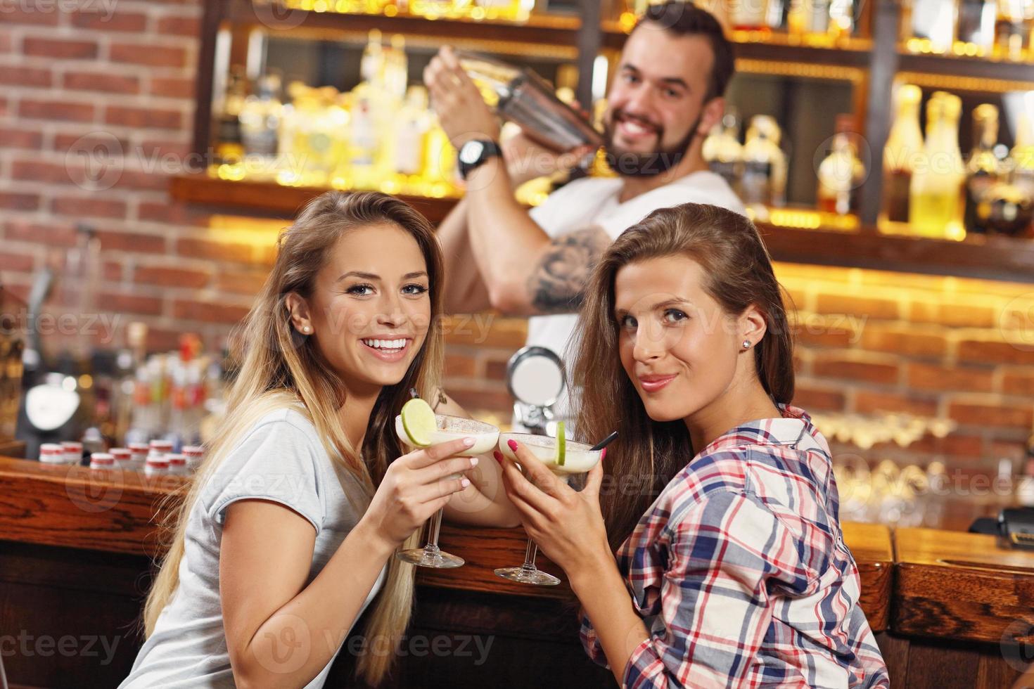 Girls friends having drinks in bar photo