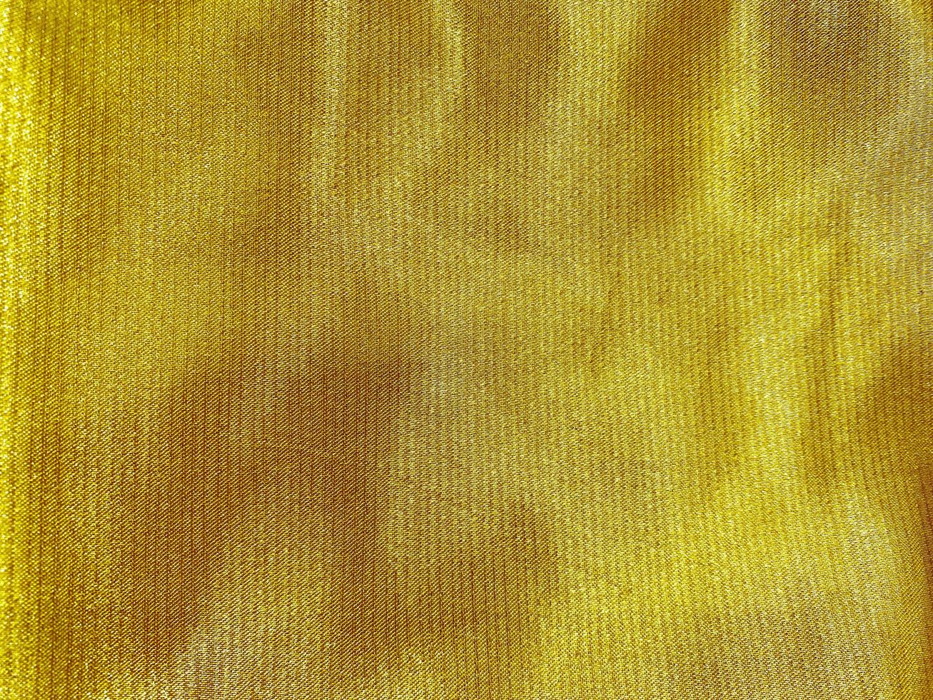 golden cloth fabric texture used as background. Empty golden cloth fabric background of soft and smooth textile material. There is space for text photo