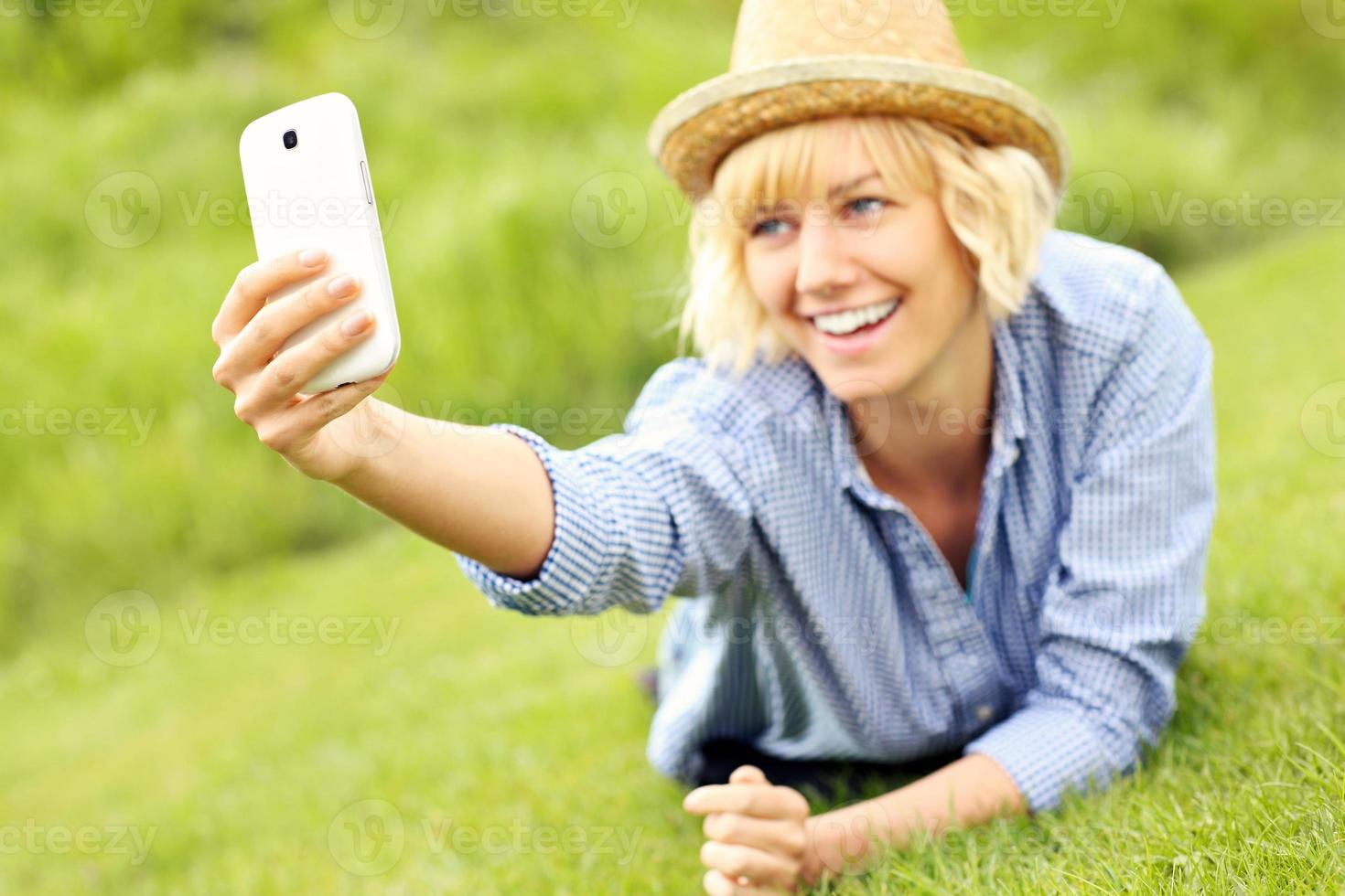 Woman taking selfie on the grass photo