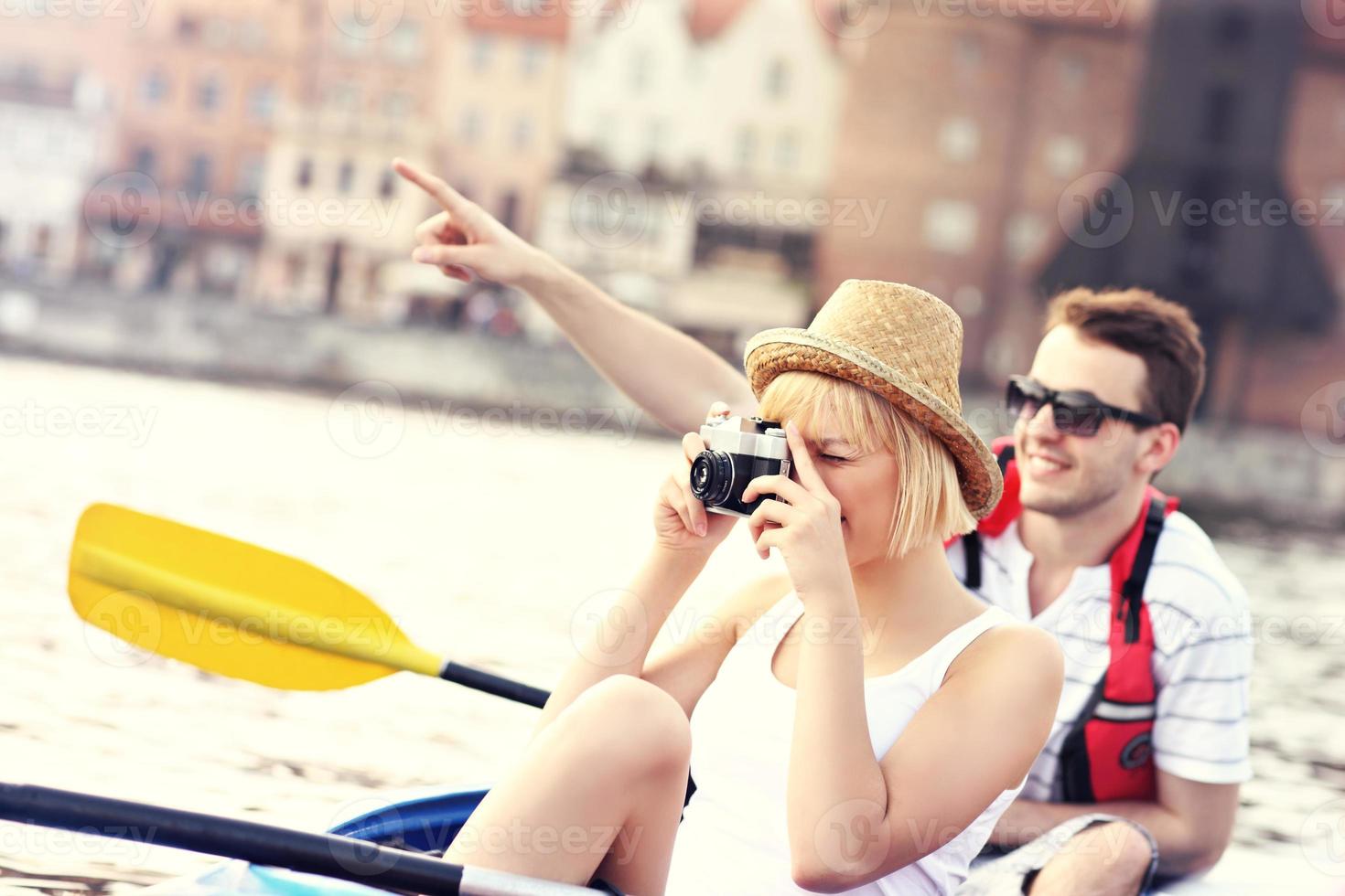 jóvenes turistas tomando fotos en una canoa