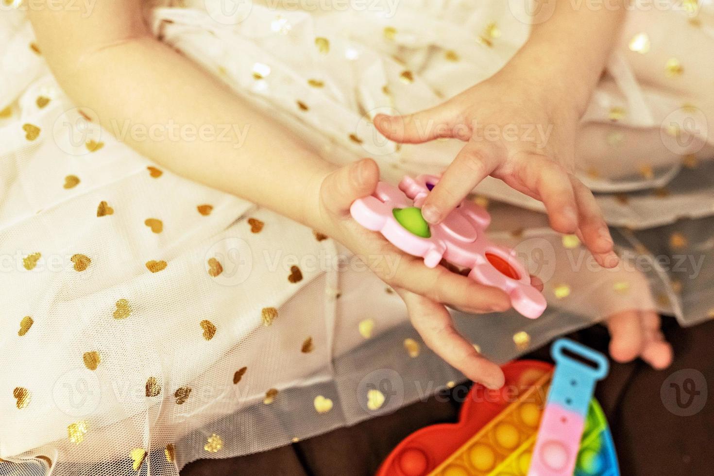 Pop it is a multi-colored anti-stress toy in children's hands. Bubble game. Antistress toys. photo