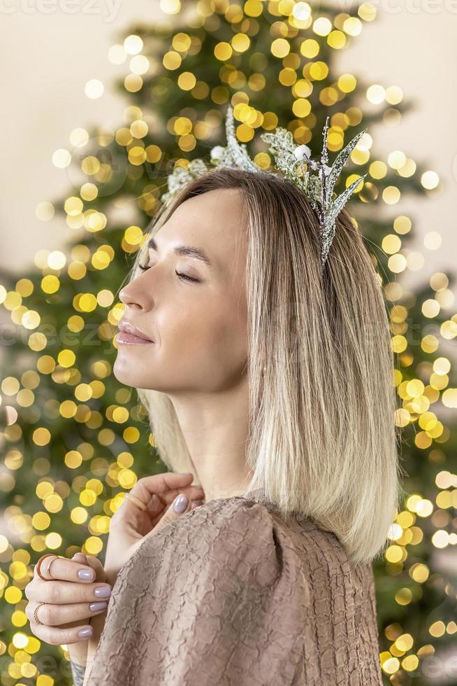 A young woman with blonde hair with a Christmas tree. New Year's concept,Christmas decorations photo