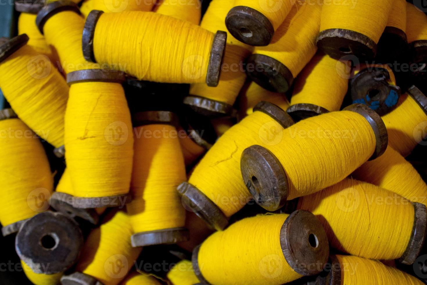 large grup yellow yarn on wood spool, yarn on tube, a collection of yellow  threads on spool, which will be fabricated. yellow string. yellow thread.  15938471 Stock Photo at Vecteezy