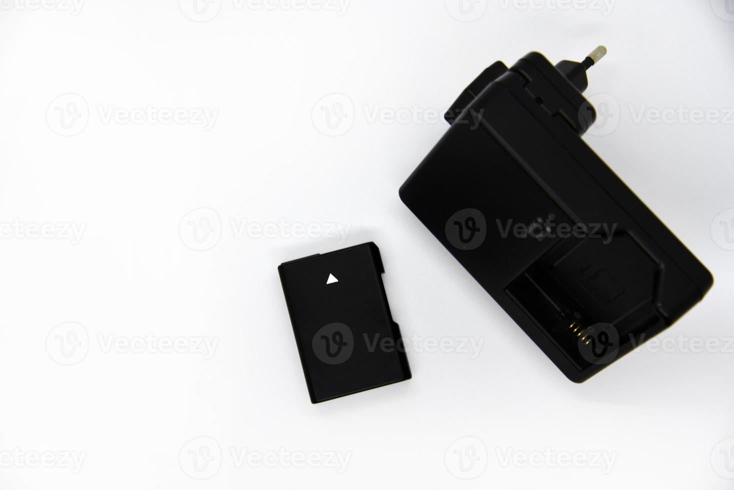 Black charger and battery for cameras. Charger and battery on a white background. Black accessories for the camera. photo