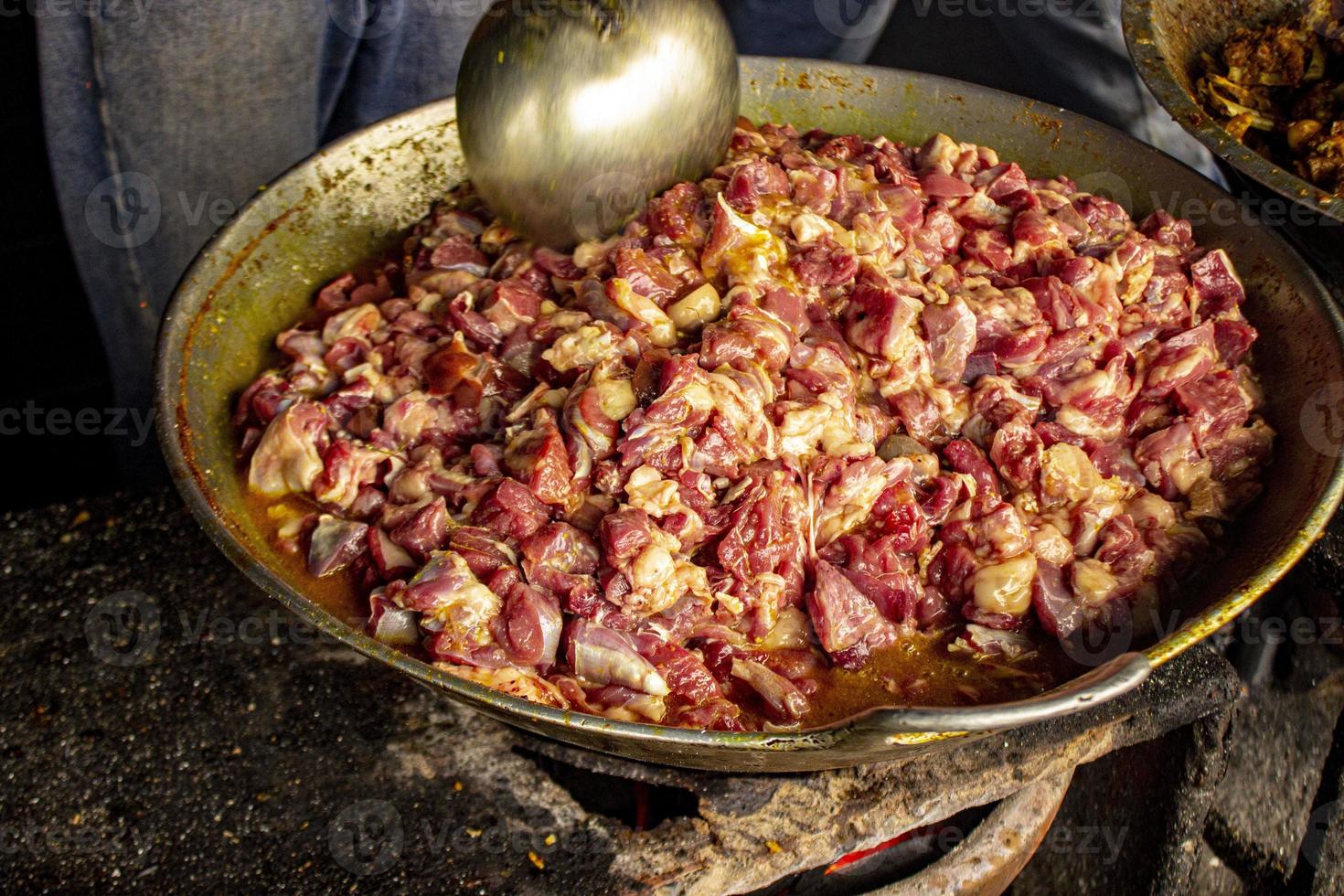 Traditional cooking raw meat with yellow curry or Tongseng in pan. Tongseng is traditional curry food from central java indonesia photo