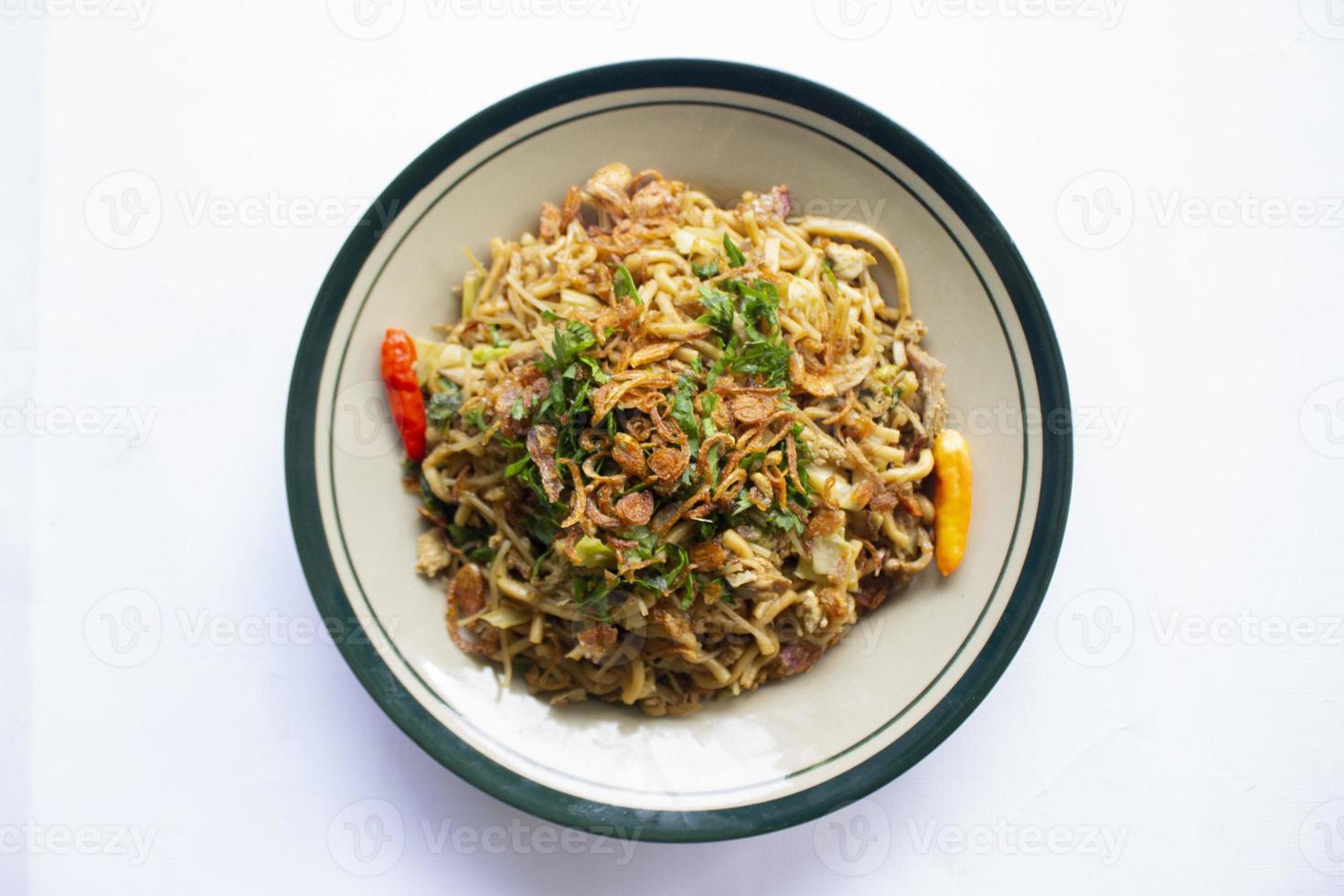 Mie Goreng Jawa or bakmi jawa or java noodle with spoon and fork. Indonesian traditional street food noodles from central java or Yogyakarta, indonesia on white background photo