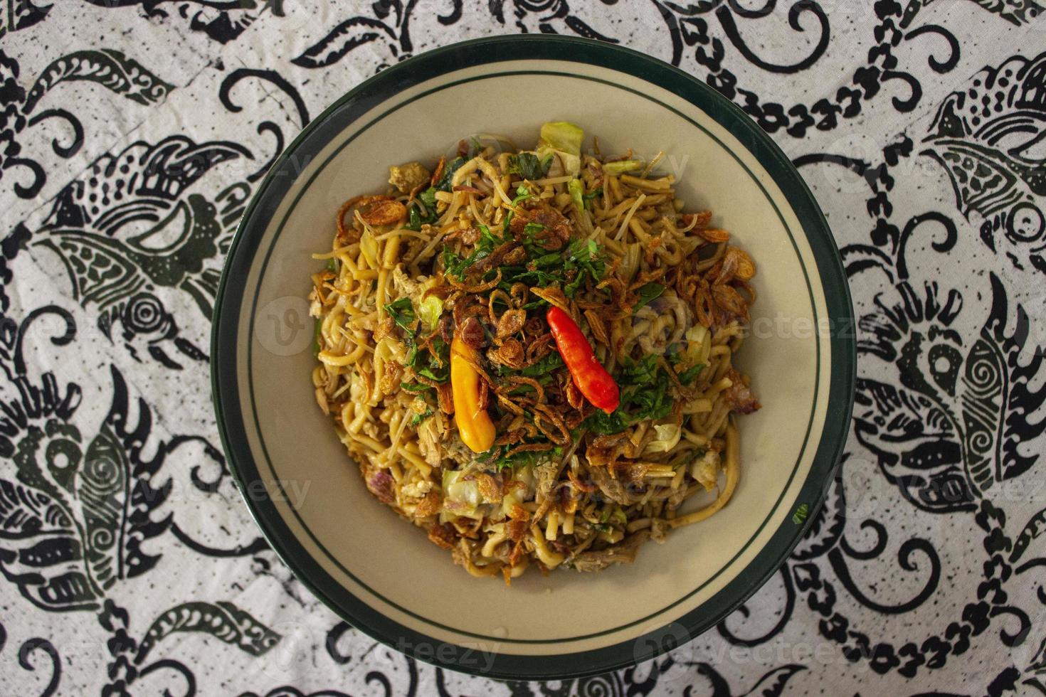 Mie Goreng Jawa or bakmi jawa or java noodle with spoon and fork. Indonesian traditional street food noodles from central java or Yogyakarta, indonesia on white background photo