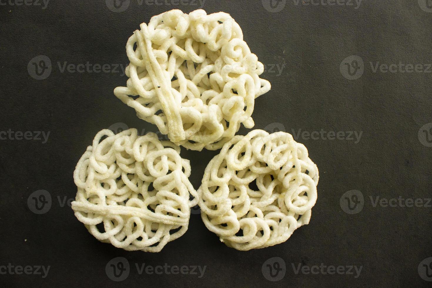 kerupuk or krupuk or crackers isolated on black background. kerupuk is snacks made from tapioca flour dough mixed with flavorings such as shrimp or fish. traditional snack from indonesia photo