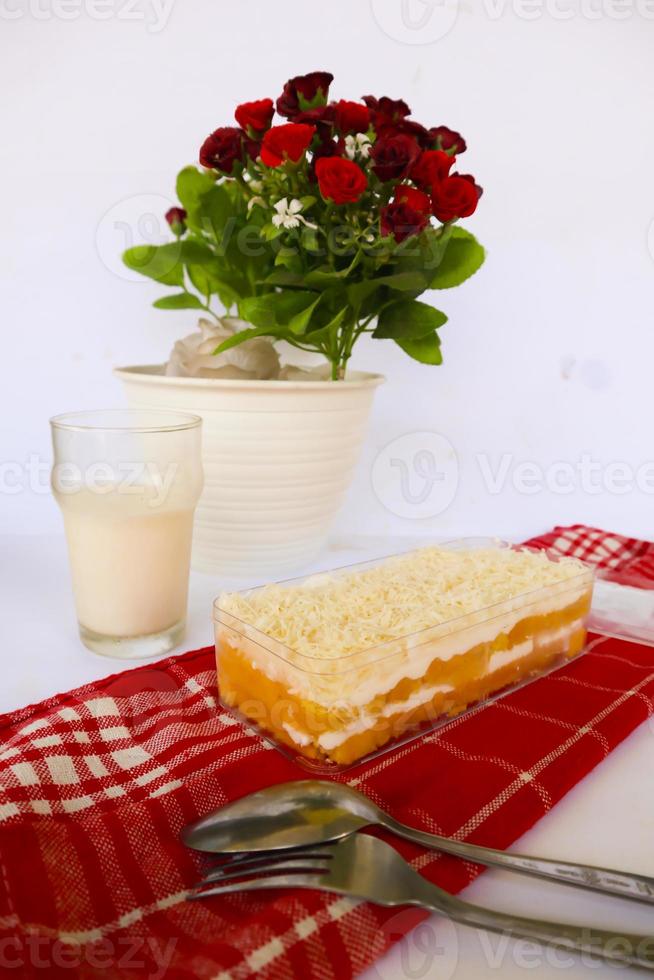 Tres Leches Cake or milk bath served with milk spoon and fork, isolated on white background photo