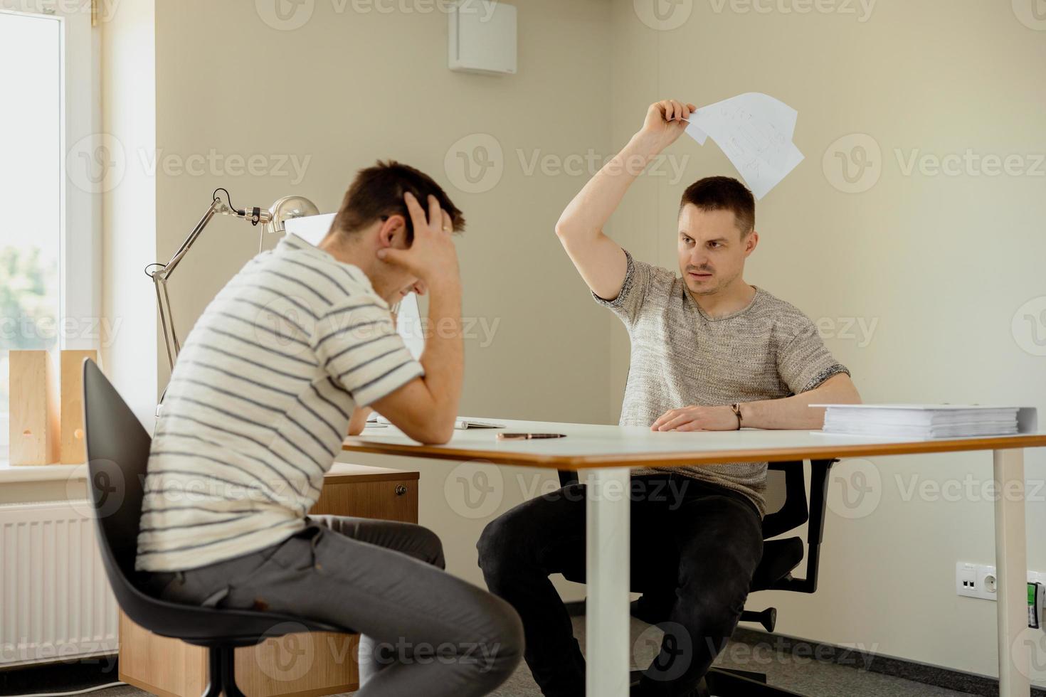 Stressed young office employee has problems at work. Boss is angry, risk of dismissal. Mental health. Overwhelmed by working. Deadline, stress. Mistake at work, negative emotions. photo
