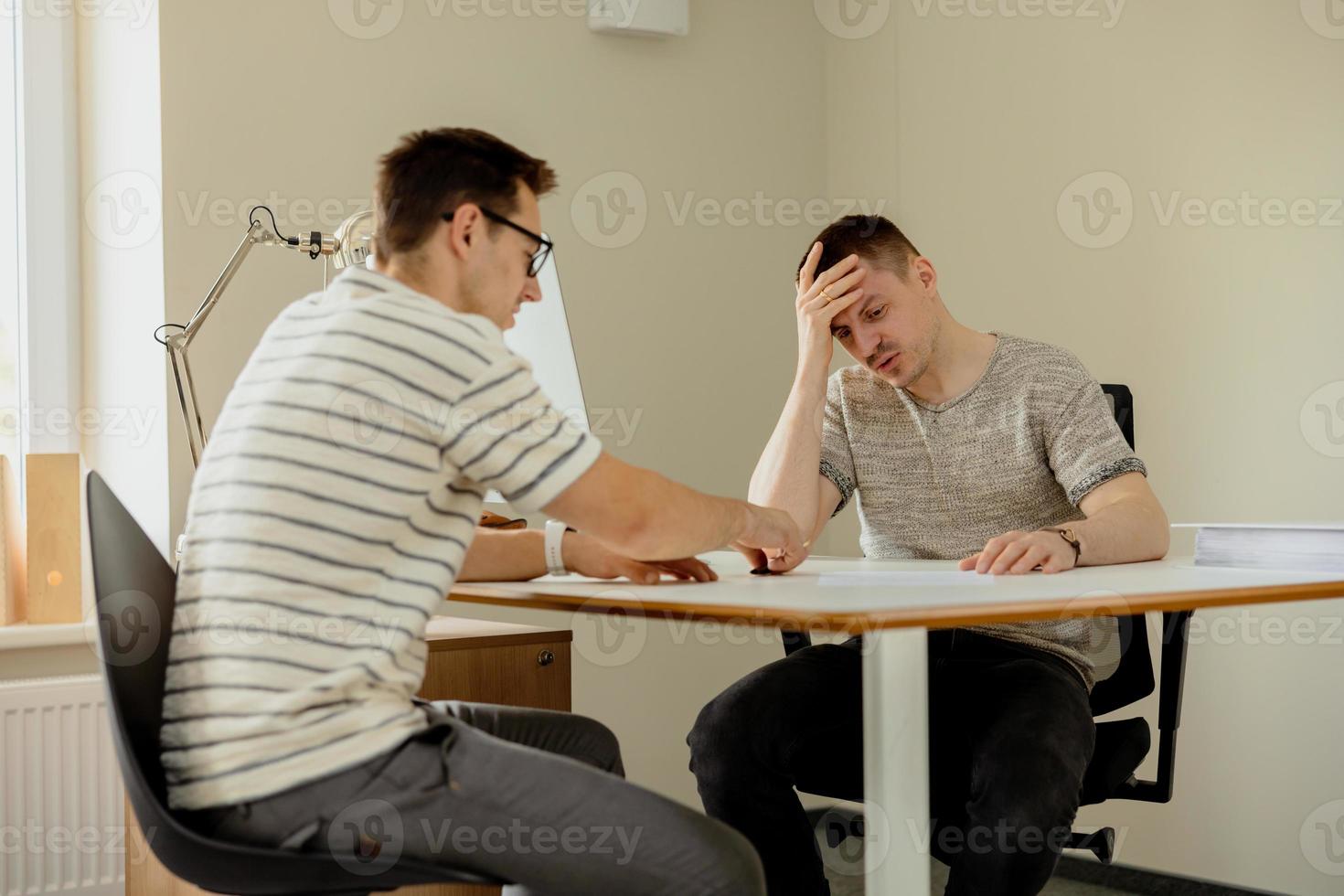 Serious professional man consulting client in office. Two mens having meeting, making business conversation. Insurer giving advice, manager making offer. Mentor teaching intern. Job interview. photo