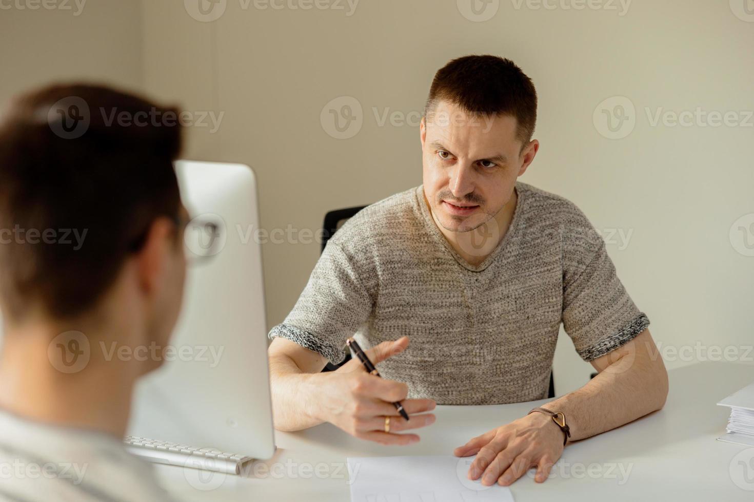 Serious professional man consulting client in office. Two mens having meeting, making business conversation. Insurer giving advice, manager making offer. Mentor teaching intern. Job interview. photo