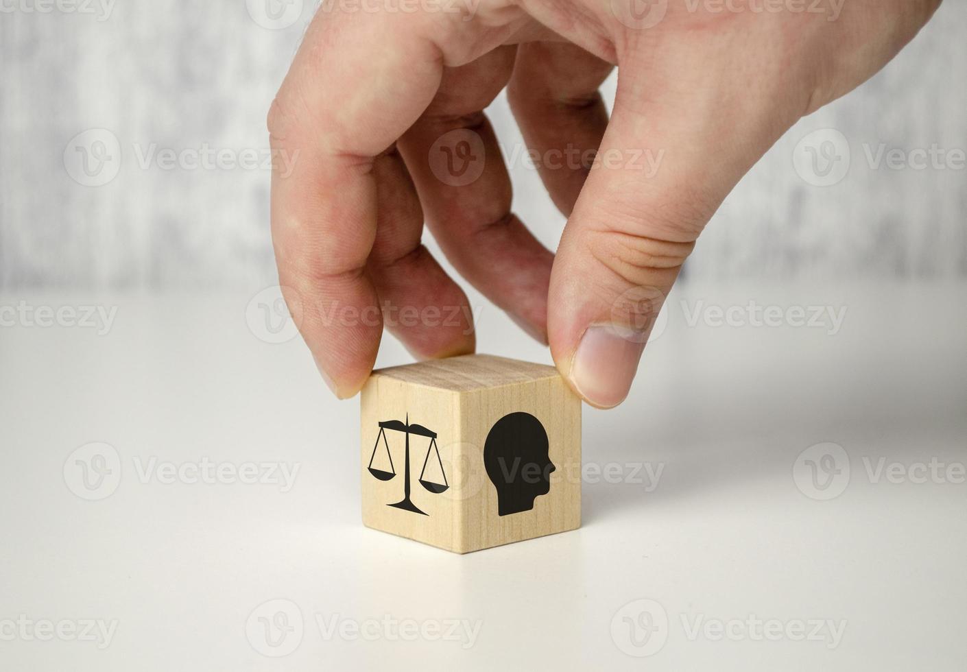 Business ethics concept. Hand flip ethics inside a head symbols in wooden cubes on dark background with copy space. photo
