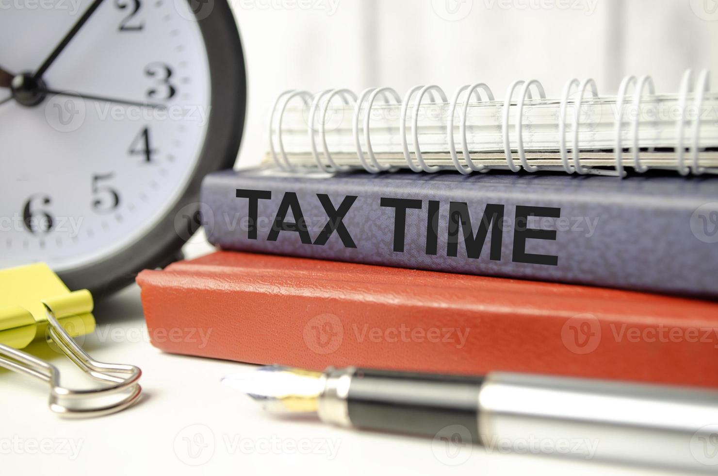 tax time on notepad with clock and pen photo