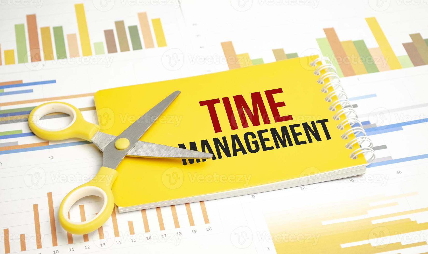 time management . Text on yellow notebook and charts photo