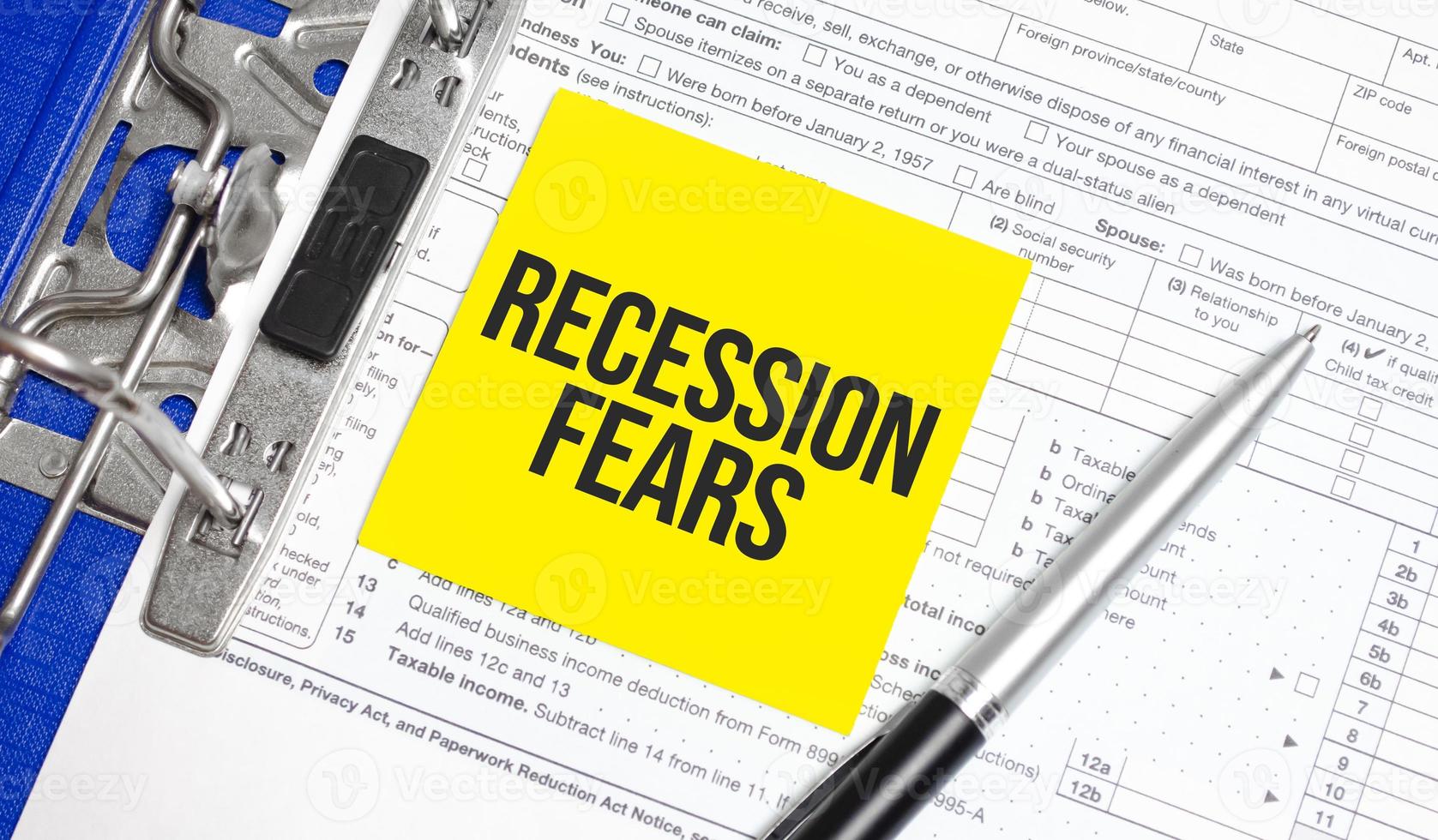 Recession fears words on paper notebook with pen photo