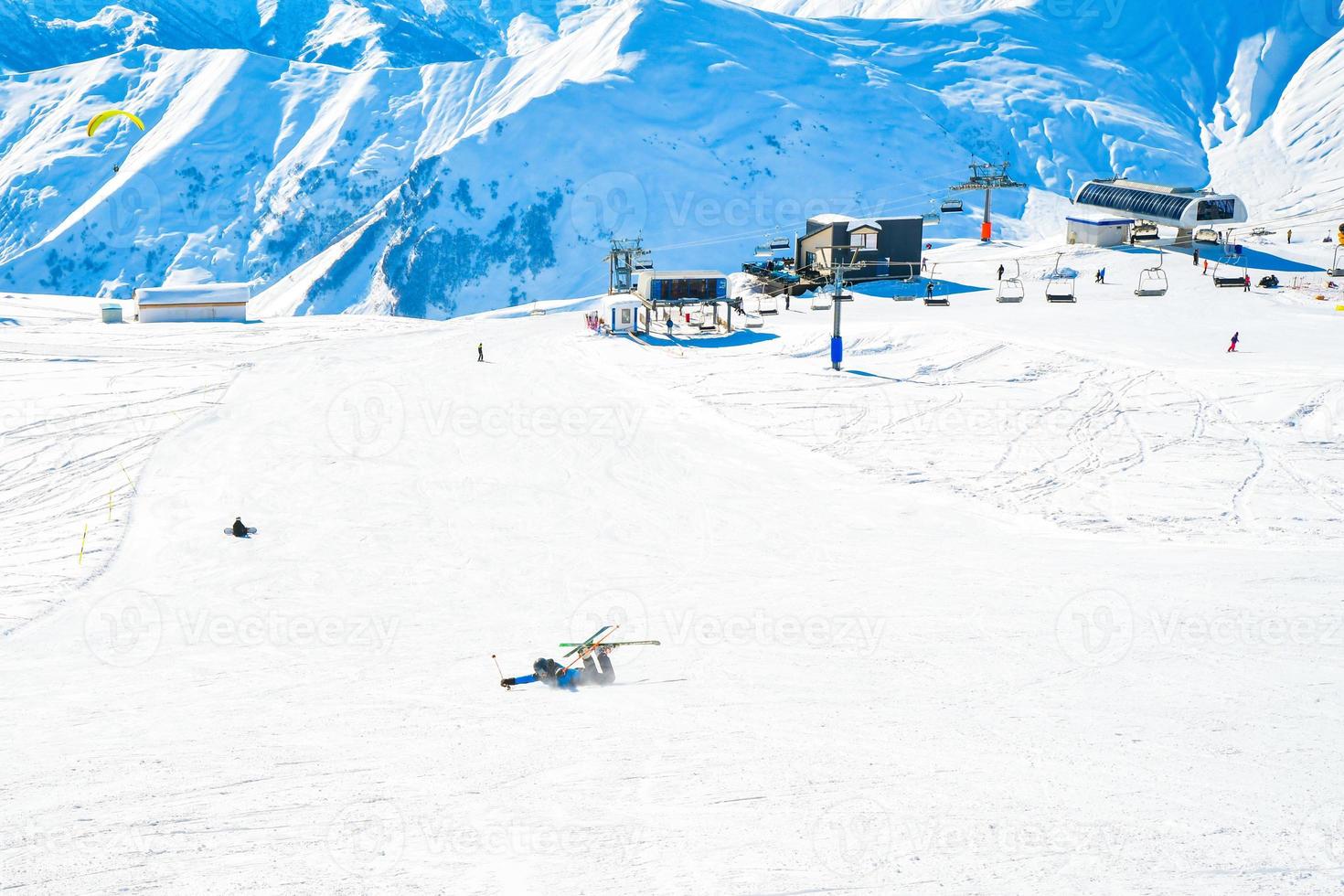 Cerrar vista snowboarder caer sobre la nieve mientras snowboard en pista foto