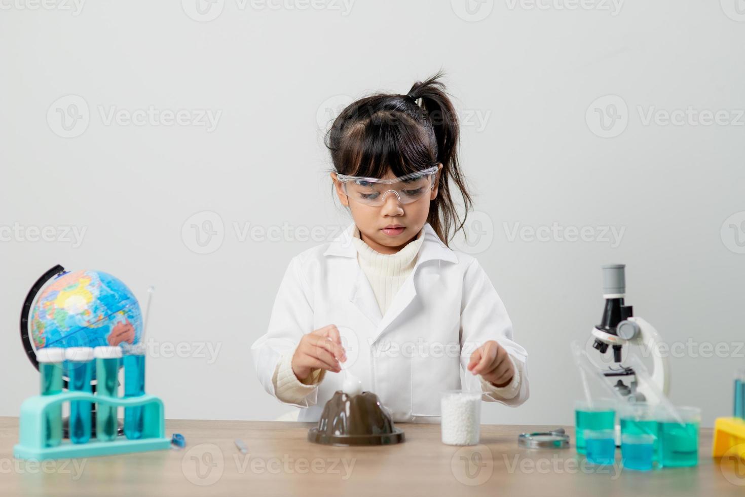 education, science, chemistry and children concept - kids or students with test tube making experiment at school laboratory photo