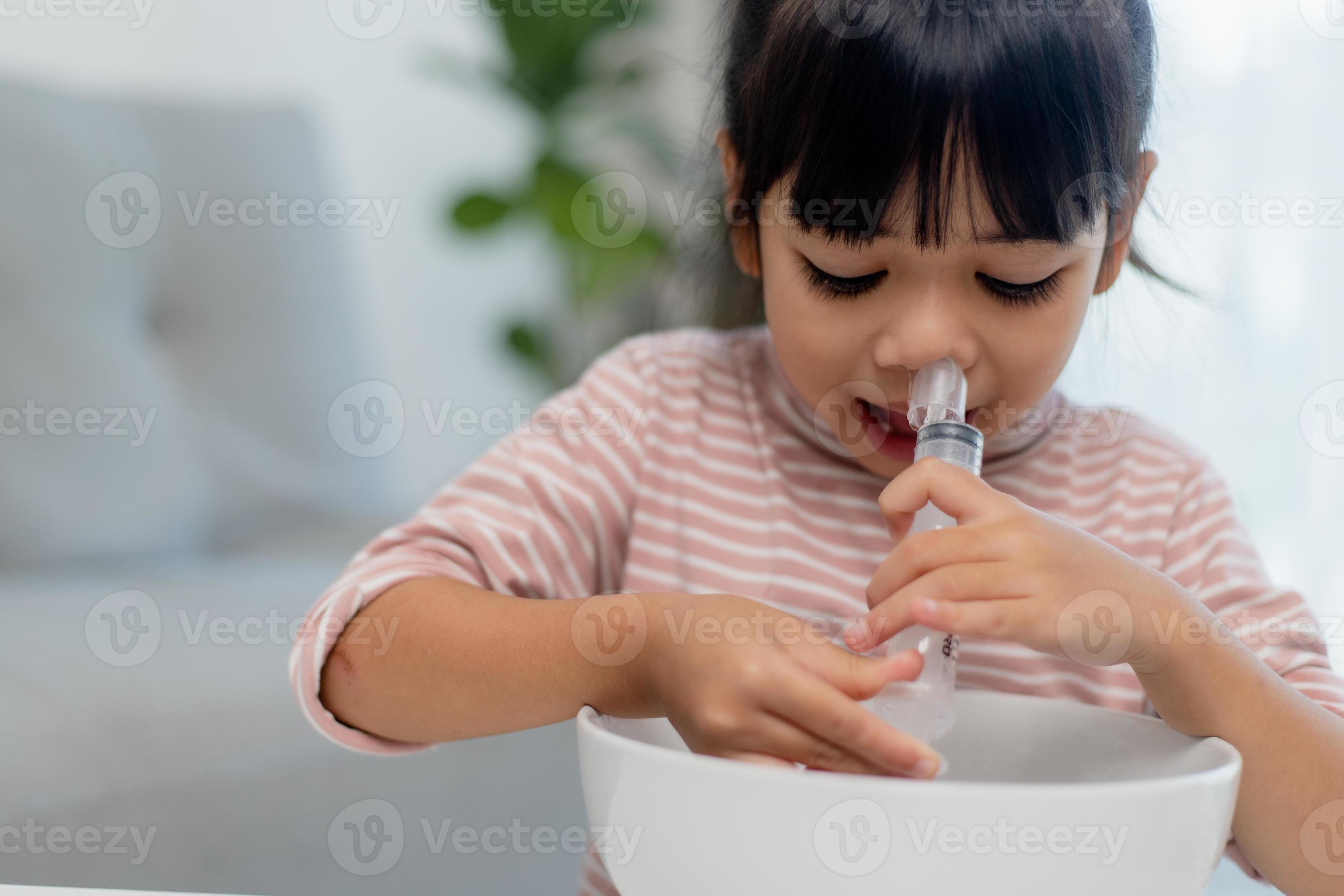 Lavado nasal. estudiantes asiáticos chica su nariz de enjuague la jeringa  con solución salina y aislado sobre fondo blanco Fotografía de stock - Alamy